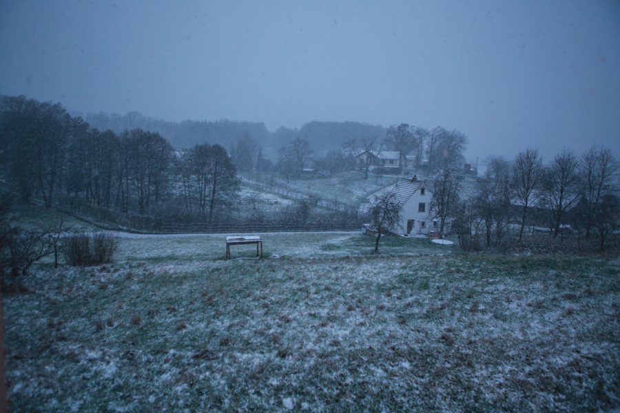 Leicht verschneite Winterlandschaft mit kleinem Haus